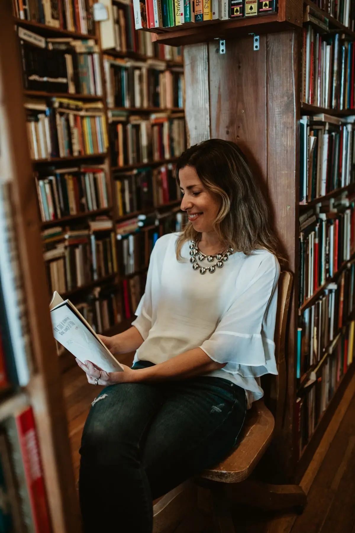 Bel imersão escrita Isabel Arruda escritora lendo um livro na biblioteca