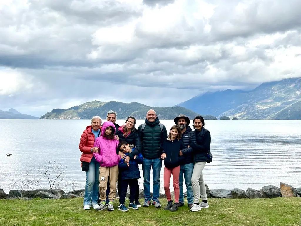 Familia reunida para foto com um lago ao fundo